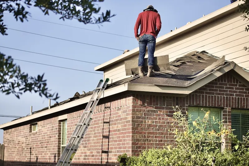 Professional roofer working on a residential roof in Ossian